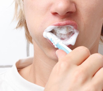 girl brushing teeth with natural toothpaste
